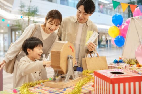 マチノマ大森の抽選会をイメージした、ショッピングモールで抽選を楽しむ親子ファミリーの実写風イメージ画像