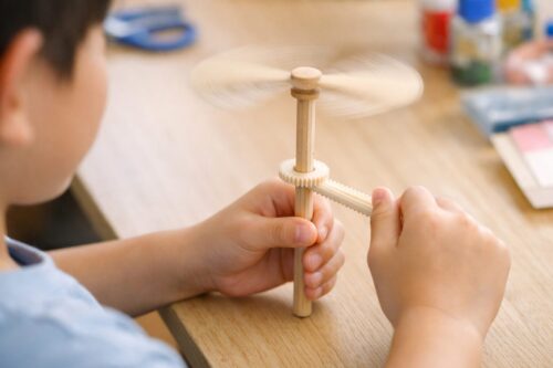 ガリガリと音を立ててプロペラを回すガリガリとんぼを、子どもが手元で操作している様子